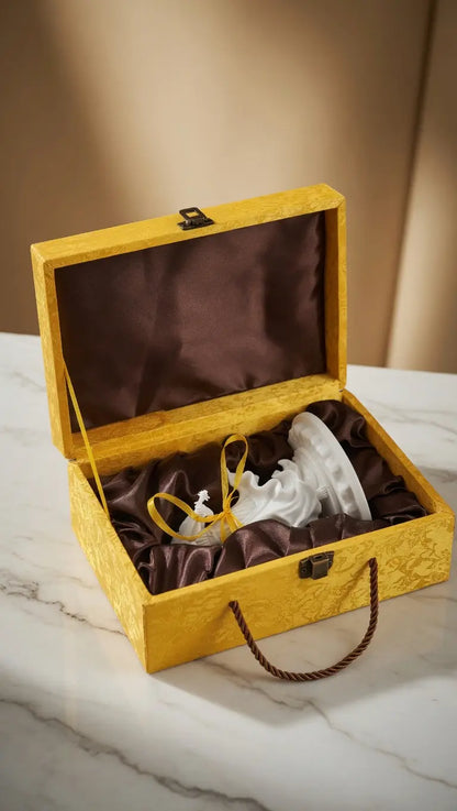 Violinist incense holder packaged in a yellow silk gift box with brown satin lining, on marble